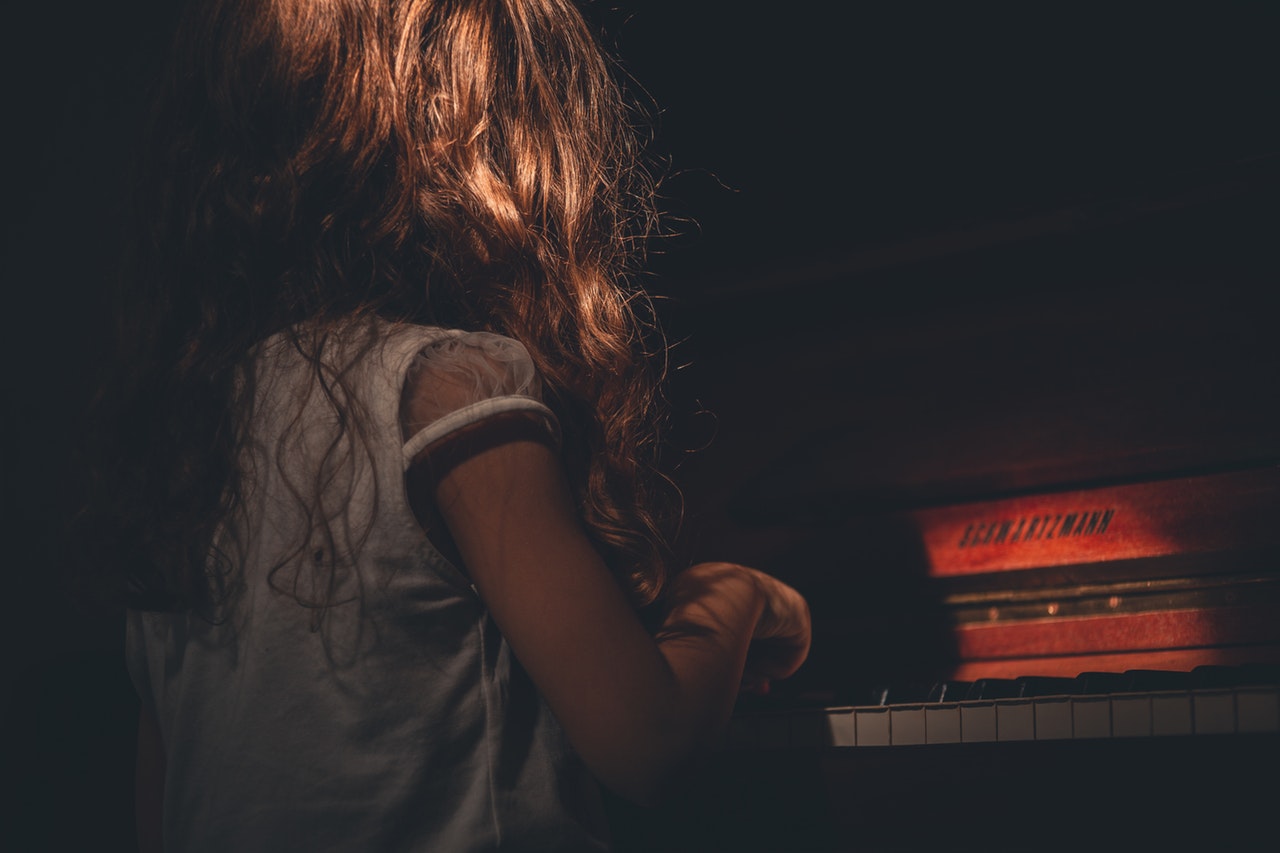 brunette little girl playing the piano