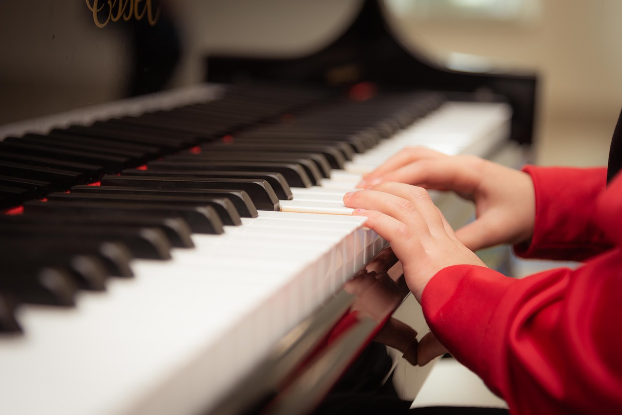kid wearing red sweater playing the piano